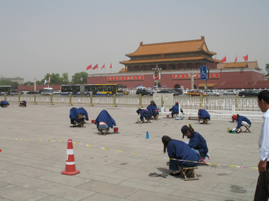 Pékin, 28 mai 2008. Par 32°C sans ombre, de jeunes travailleuses nettoient les dalles de la place Tian'anmen.